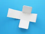 Een uitgeknipte kartonnen bouwplaat voor een dobbelsteen met deels gevouwen flapjes.