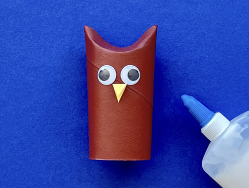 Moeder en dochter knutselen aan het bureau met een wc-rol, papier en pennen om dieren te maken