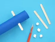 De keukenpapierrol, lollystokjes, kleine propjes wc-papier en een knutselmes.