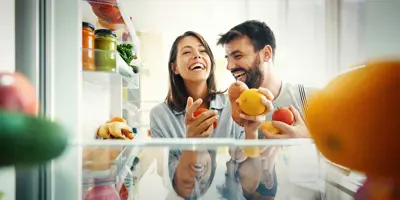 Een stel haalt wat fruit en groenten uit de koelkast