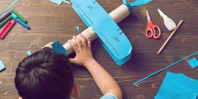 Kind bouwt een doet-het-zelf kartonnen vliegtuigje