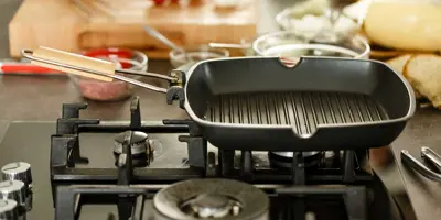 Lege, schone grillplaat op gasfornuis