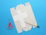 Kubussjabloon ligt op een opengevouwen tissuedoos met een potlood en een schaar ernaast.