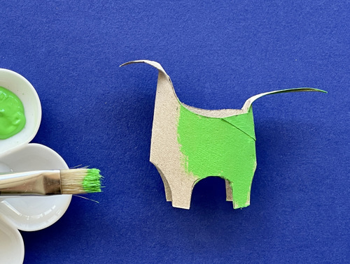 Moeder en dochter knutselen aan het bureau met een wc-rol, papier en pennen om dieren te maken