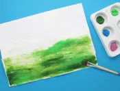 Repen gescheurd keukenpapier die op een vel papier zijn geplakt worden in diverse tinten groen geverfd.