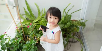 Klein meisje verzorgt kamerplanten