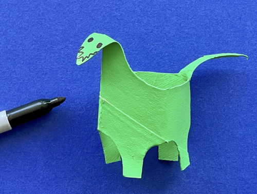 Moeder en dochter knutselen aan het bureau met een wc-rol, papier en pennen om dieren te maken